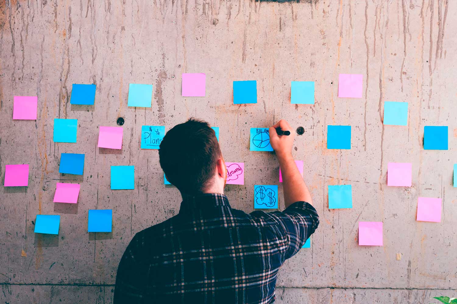 mies ideoi liiketoimintasuunnitelmaa post it-lapuilla